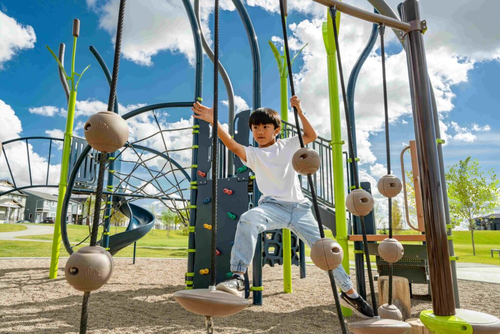 child playing on green and blue playground equipment